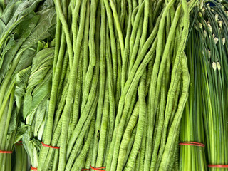 Heap of fresh yardlong beans (Asparagus bean) on shelf at a fresh market
