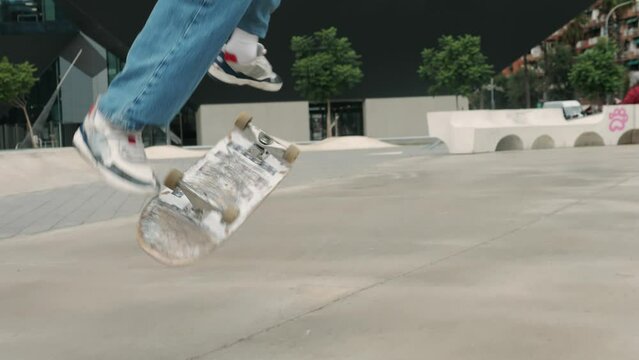 Young skater making 360 flip jump, performing kickflip trick, skateboarder training in skatepark, making tricks, slides and flips, professional extreme sport athlete training ride on skateboard. 