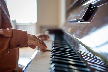 Closeup of musician hands playing piano keyboard, improvising, performing music for meditation,...
