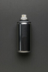 Metal aerosol can on a gray background.