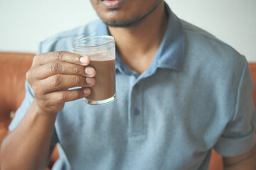 child drinking tasty chocolate milk at home.