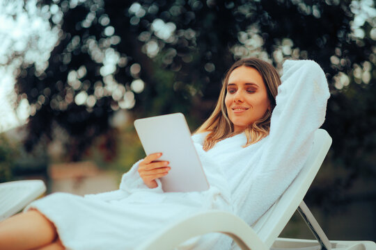 Happy Woman Relaxing on Vacation Checking her Pc Tablet. Happy person working remotely and resting in the same time 
