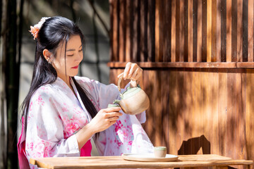 Pretty asian woman wearing Japanese traditional kimono.  Asian woman sitting near a low table.Young...