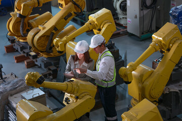 Experts Analyzing Automated Machinery in High-Tech Robotics Lab