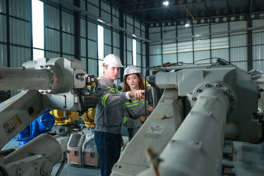 Engineers Conducting Precision Analysis in Robotic Arm Assembly Area