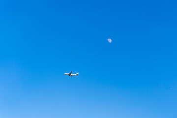 Naklejka na ściany i meble airplane flying over sky moon