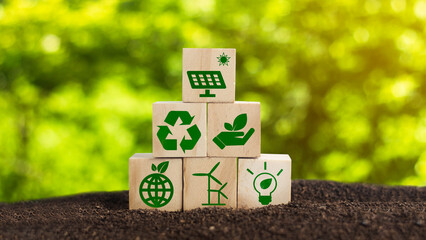 Sustainable living concepts. Wooden cubes with icons representing the use of renewable energy are...