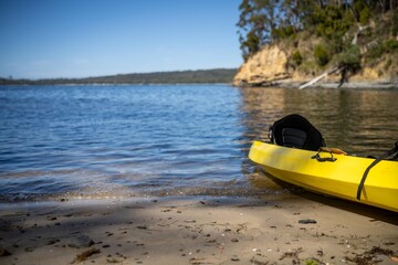 yellow canoe and kayak on a sandy beach in Australia in summer. kayaking on the sea in tasmania