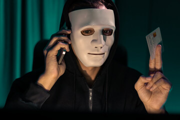 White criminal anonymous mask calling to credit card owner to threaten ransom with privacy...