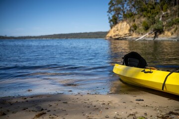 yellow canoe and kayak on a sandy beach in Australia in summer. kayaking on the sea in tasmania