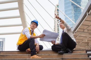 Engineer and foreman worker checking project at building site, Engineer and builders in hardhats...