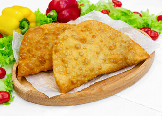 Cheburek with meat on a wooden board