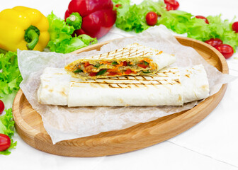 Shawarma, doner with meat, tomatoes, cucumber and vegetables on a wooden board