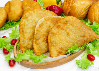 Assorted pastries, buns, pies, pasties on a wooden board