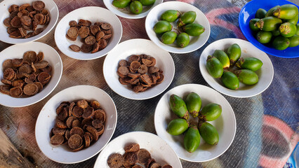 Plates of fresh and dried betel nut, areca nut, at a local market stall in West Papua, Indonesia