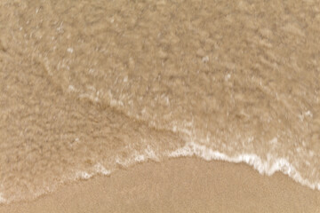 Beach sand texture with sea water, closeup