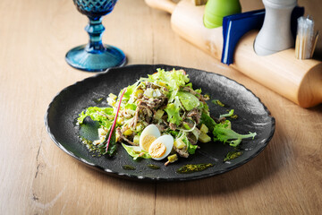 Salad of beef, lettuce and egg on a plate, lunch, cafe restaurant