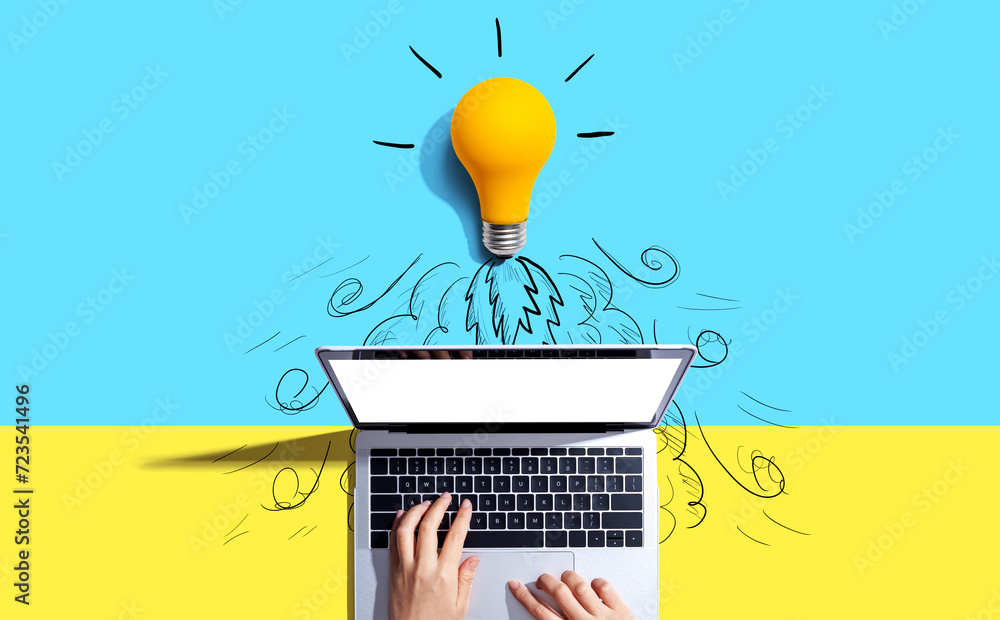Poster idea light bulb flying to the sky like a rocket from a laptop computer - flat lay