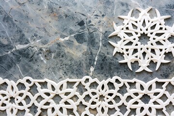 grey marble surface with intricate white decorative elements placed on top