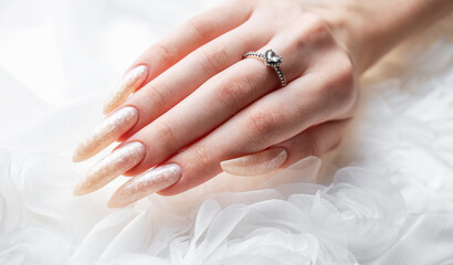 Hand of a young woman with white pearl  manicure