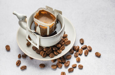 Drip coffee bag with ground coffee in  cup