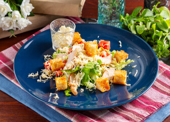 Caesar salad with chicken and vegetables on the table, cafe, lunch