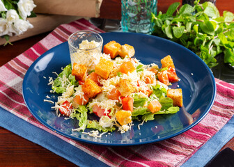 Caesar salad with salmon and vegetables on the table, cafe, lunch