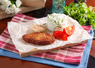 Meat cutlet with rice and sauce on the table, cafe, lunch