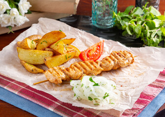 Chicken shashlik with potatoes on the table, cafe, lunch