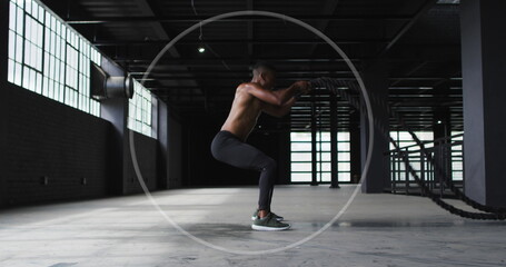 Young biracial man performs squats at a gym - Powered by Adobe