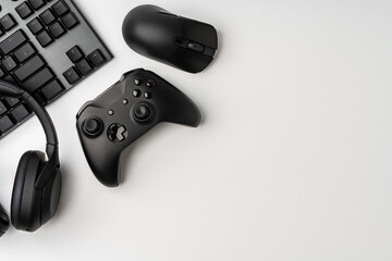 Top view of gamer table with computer keyboard, joystick and headphones