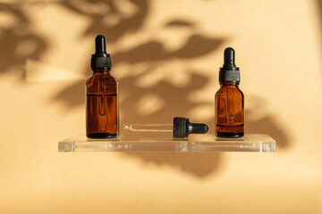 Bottles of whey on glass platform. Amber containers with retinol in sunlight. Cosmetic packaging on...