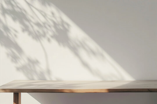 Minimal style interior white room with sunlight, leaves shadows and wmpty wooden table. Copy space