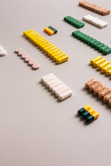 Fototapeta premium meds, pills, tablet, capsules, colored pills, line, group, many, sorting, drugstore, oral, vitamins, probiotics, food supplements, dietary supplements, white, green, yellow, colored, narcotic, aspirin