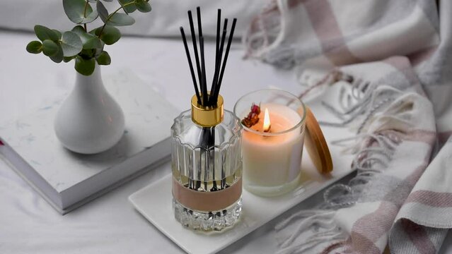 Aroma scented reed diffuser glass is on the tray with scented candle