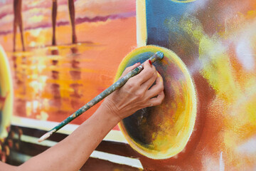 Female painter hand draws picture with paintbrush on canvas for exhibition, close up view of female...