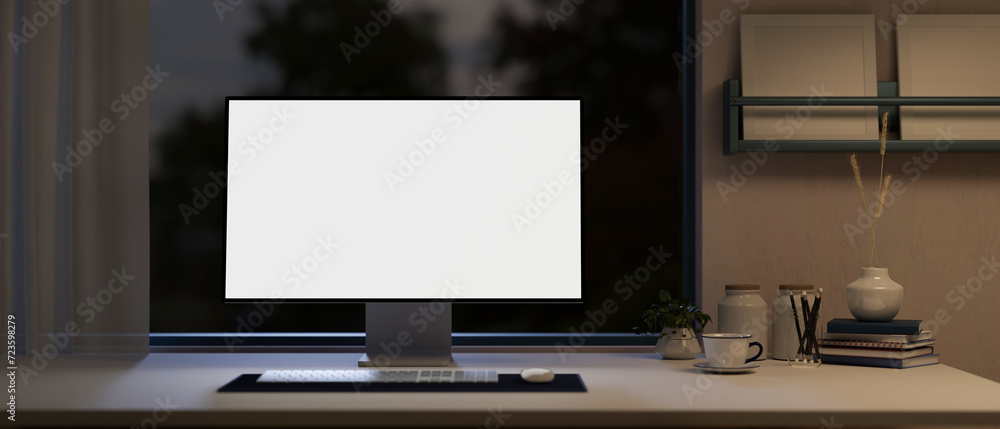 Poster front view of a white-screen computer mockup on a table in a modern home office at night.