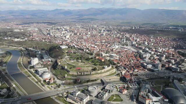 Drone view of the city of Skopje crossing the Vardar River, stone castle in the city center