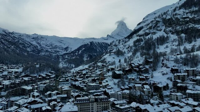Slow drone flyover of Zermatt Switzerland and the matterhorn during winter. Ski resort and mountain town in the European Alps