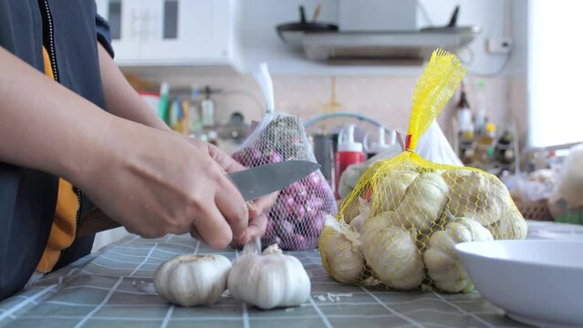 Woman peeling the garlics preparing for cooking the food
