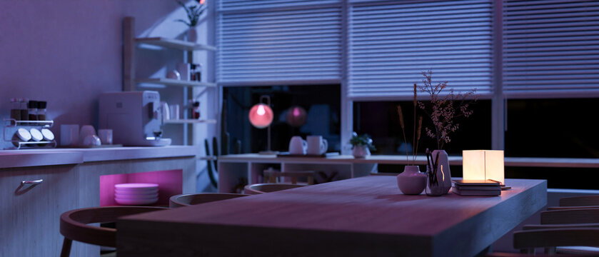 A hardwood kitchen dining table in a modern spacious kitchen at night with RGB lights.