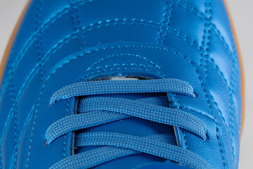 Part of a blue leather lace-up sneaker close-up. Shoe leather close-up.