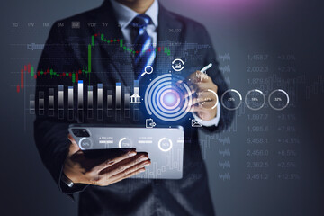 Market analysis concept with businessman using tablet to analyse financial chart information in...