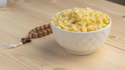 Millet porridge and prayer beads on a wooden table during the Great Christian Fast. Lenten food during the Great Orthodox Lent
