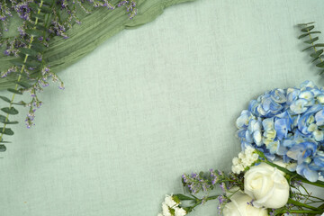 Blue hydrangea flower with greenery on green background. with copy space