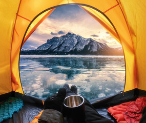View from inside a tent of tourist relaxing and looking to the rocky mountains with bubbles frost...