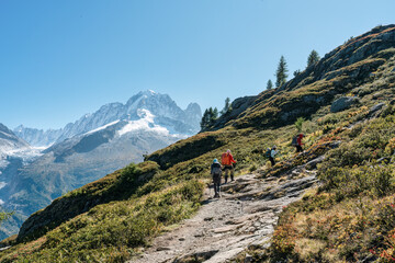 Fototapeta na wymiar Group of hiker hiking on summit trail amidst the French alps on sunny day at France