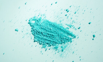 Smear of broken blue eyeshadow on a blue background. Cosmetics texture