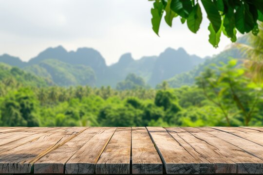 A wooden table on the background of a summer mountain landscape. Wooden surface on a background of deciduous, green trees.