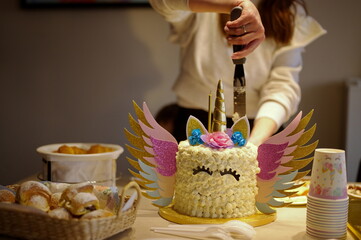 Midsection of mother cutting birthday cake